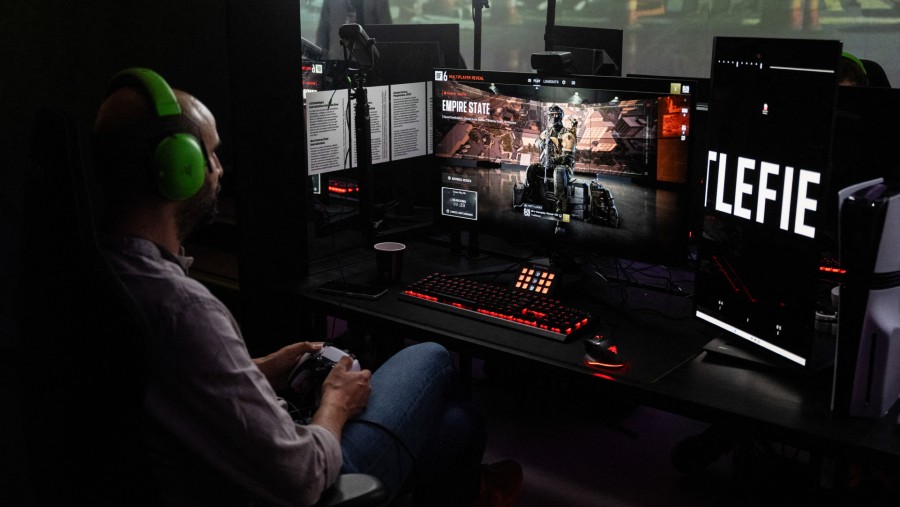 Pemain game online duduk lelah di depan komputer dengan postur tubuh tegang