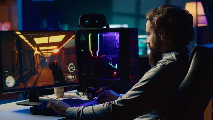 Gamer sedang bermain game online di komputer dan smartphone dengan suasana modern dan pencahayaan neon gaming